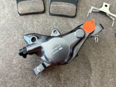 Shimano XT M8100 hydr. brzd. strmeň, Post Mount + platničky s chladičom J04C