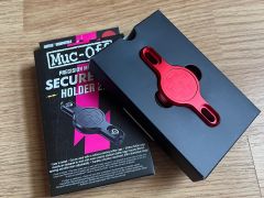 Nový Muc-Off Secure Tag Holder 2.0 - držiak na lokátor, pod košík, červená