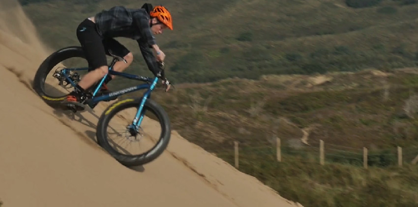 Fatbike a Chris Akrigg s jeho par&aacute;dičkami na piesku, kameňoch, skal&aacute;ch aj vode